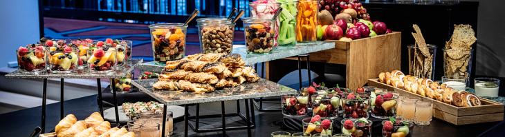 Breakfast buffet featuring fresh fruit, pastries, juice, coffee and tea