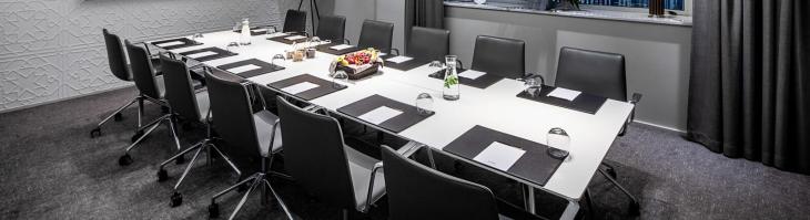 prepared meeting table in a brightly lit conference room