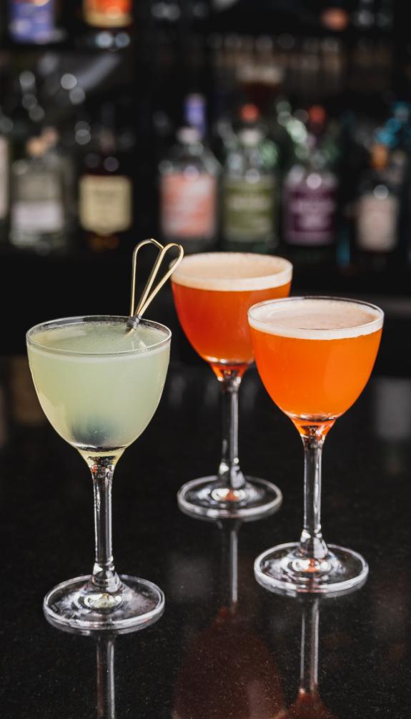 three cocktails on bar desk, vertical